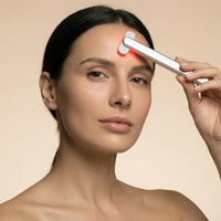 Woman using the NiceBeam 4-in-1 red light therapy skincare wand on her forehead
