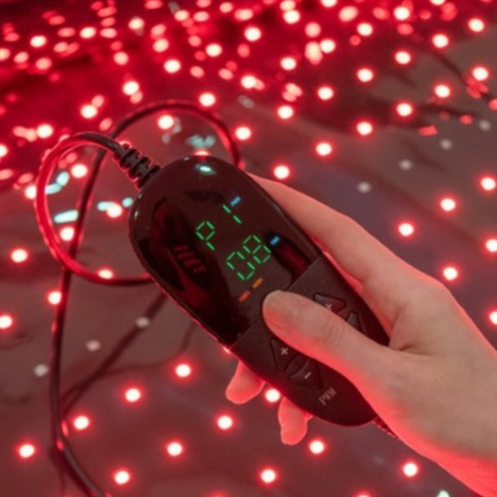 Hand adjusting the settings on the RLB BlinkRecover red light therapy bag, demonstrating customizable light therapy options for tailored treatments