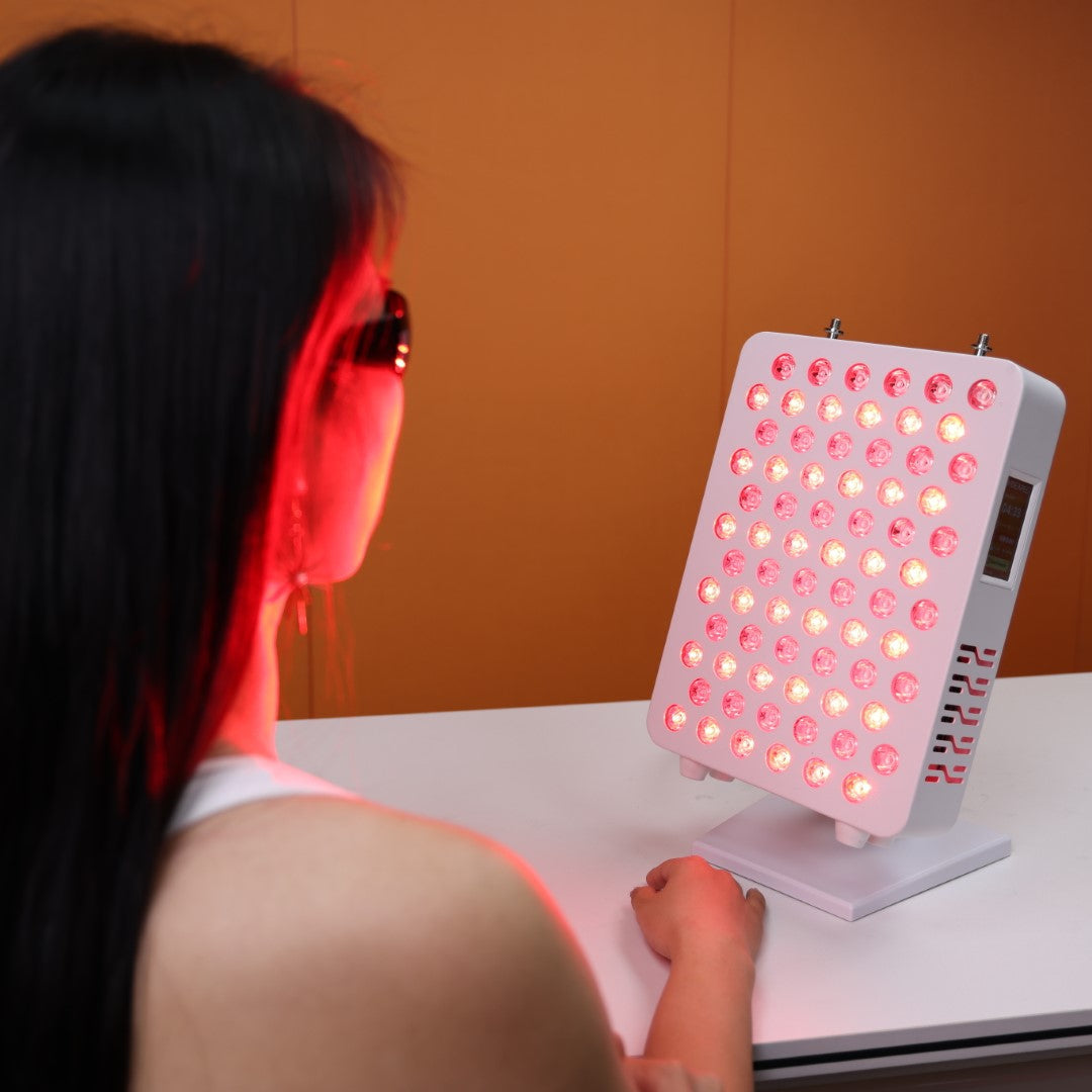 A user engaging in a red light therapy session with the Nicebeam Red Light Therapy Panel. The panel emits therapeutic red and near-infrared light, illuminating the user&