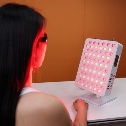 A user engaging in a red light therapy session with the Nicebeam Red Light Therapy Panel. The panel emits therapeutic red and near-infrared light, illuminating the user&