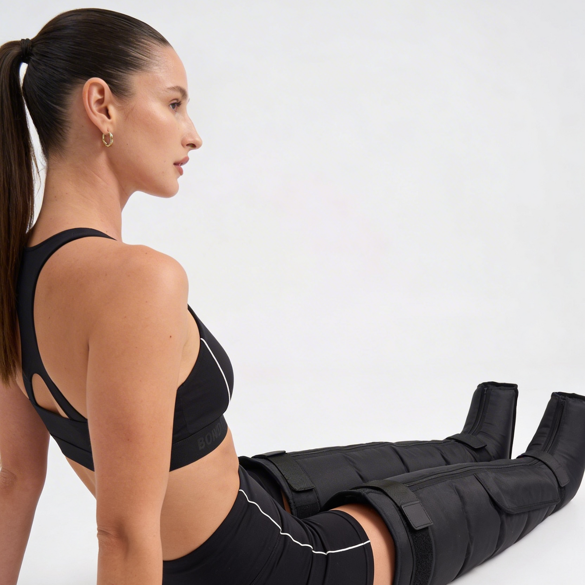 Woman wearing a black leg brace on a white background