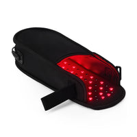 Black foot therapy device with visible red and infrared LED lights glowing inside