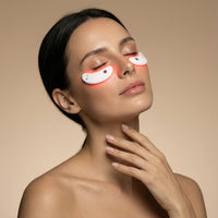 Woman using under-eye red light therapy patches for skincare and wellness