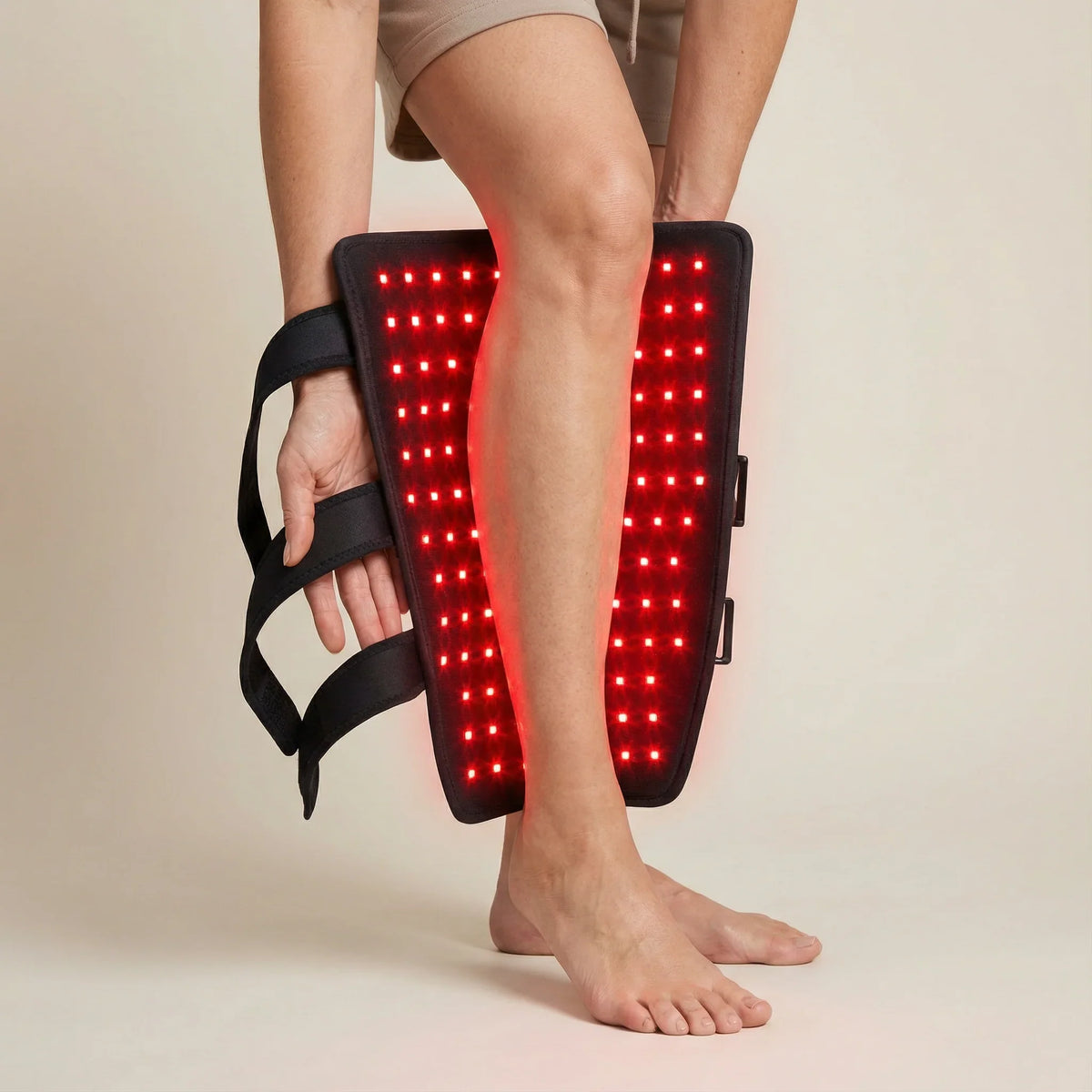 Person using the NiceBeam red light therapy leg wrap strapped to their lower leg