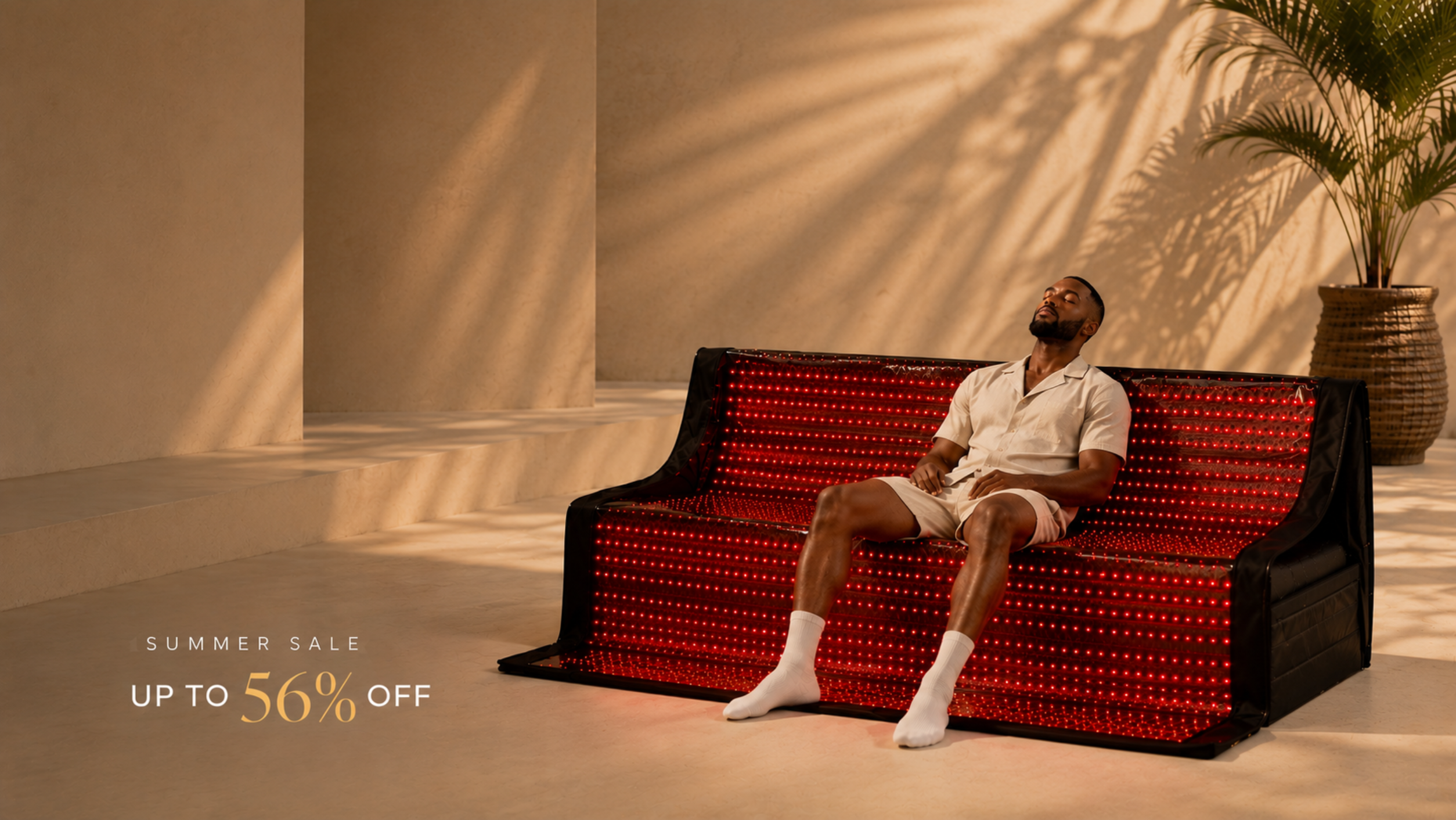 A man reclines on a red and black studded sofa in a sunlit interior with palm shadows, alongside a potted plant and a 'Summer Sale Up to 56% Off' promotional text.