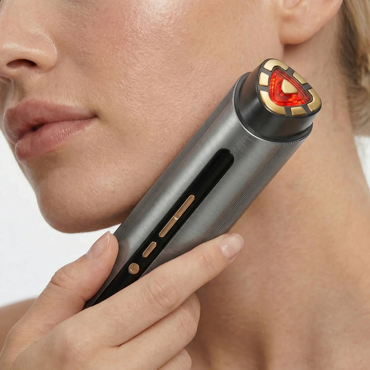 Woman using the NiceBeam red light and radio frequency facial device along her jawline