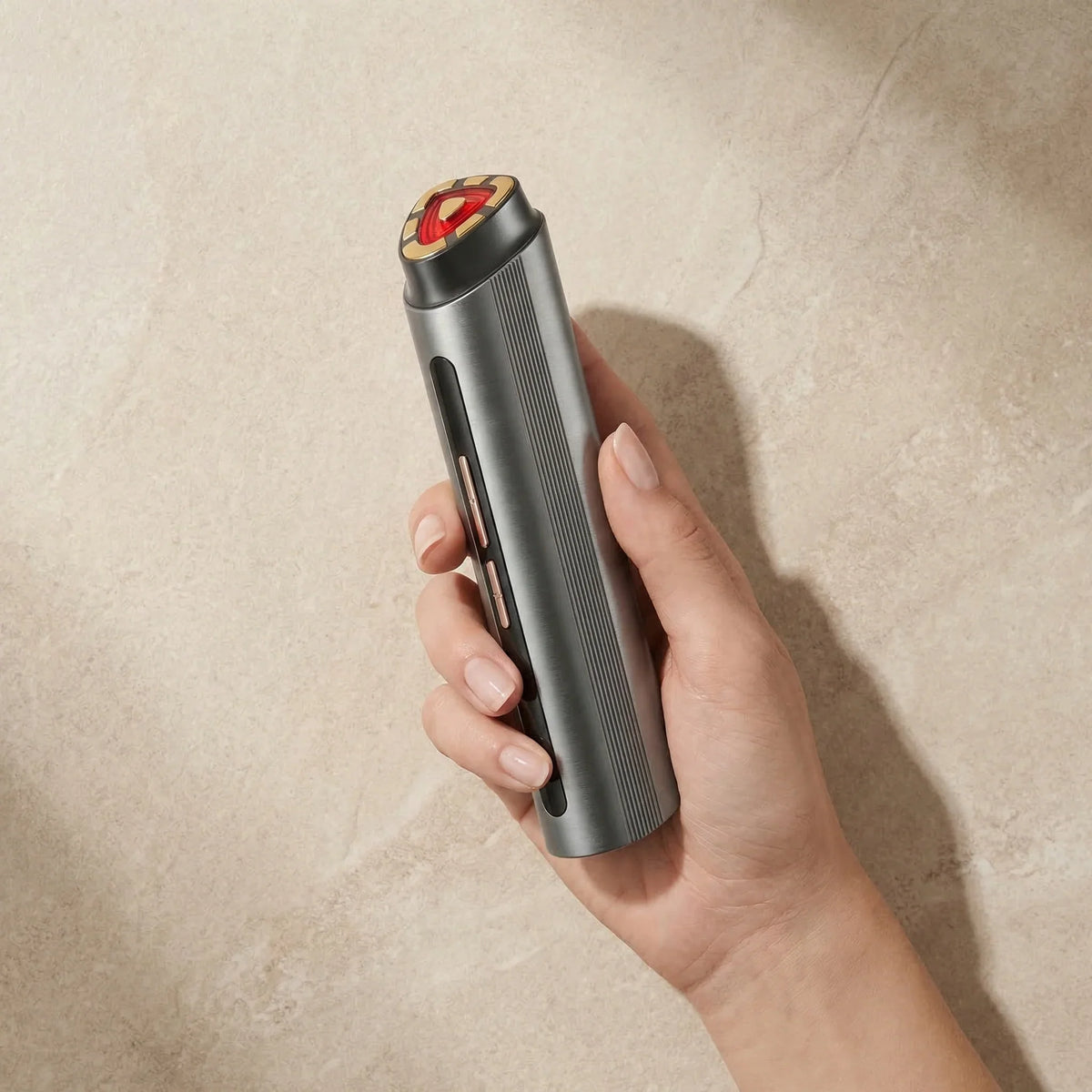 Hand holding the portable NiceBeam red light and radio frequency facial device