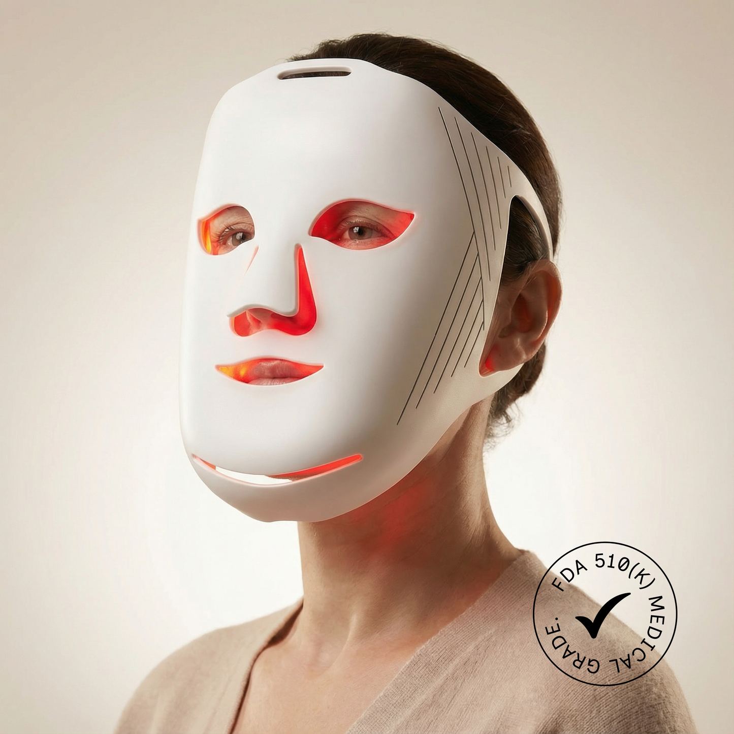 Person wearing a LED face mask with visible FDA approval label on a neutral background